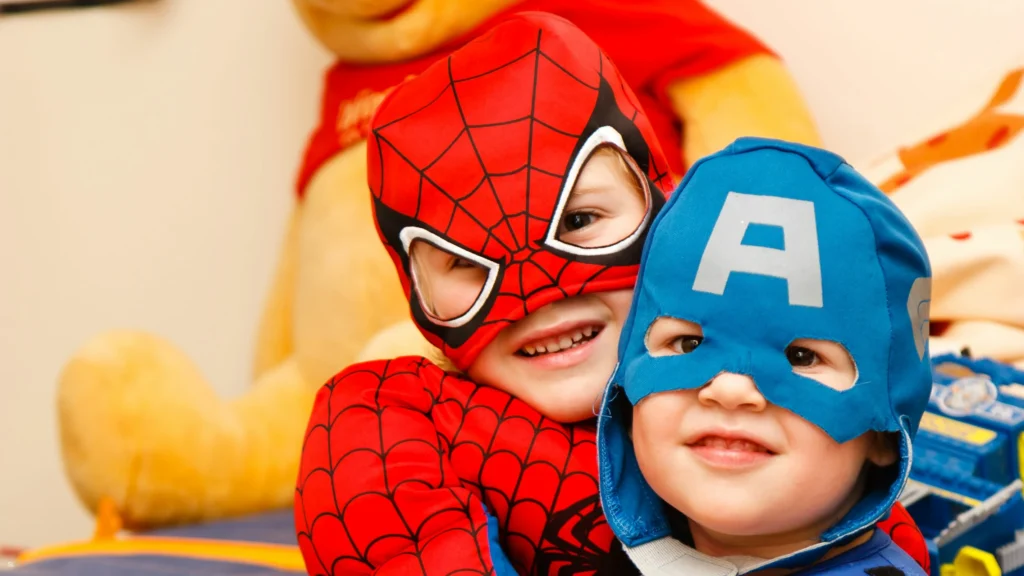 STORYTIME Two preschoolers in superhero costumes ready for storytime